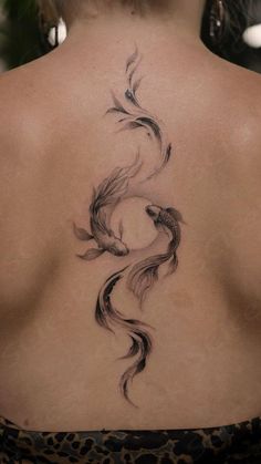 the back of a woman's neck with a fish tattoo on it