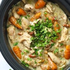 a crock pot filled with chicken and carrots