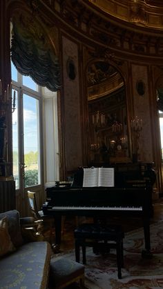 a grand piano sitting in the middle of a living room next to a large window