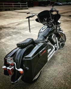 a black motorcycle parked on top of a parking lot