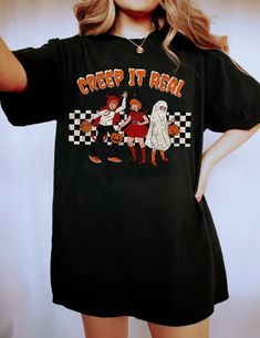 This cute vintage shirt is perfect for anyone who loves creepy, retro vintage halloween themes. Perfect for your favorite teacher, or as a gift for that special someone in your life. Retro Halloween, Creep it Real Shirt, Vintage Halloween Shirt, Witch Shirt, Retro Fall Shirt, Faded Fall Shirt, Teacher Halloween Shirt Overview -These t-shirts have-ribbed knit collars to bolster shaping. -The shoulders have taping for better fit over time. -Dual side seams hold the garment's shape for longer. -100 Vintage Black T-shirt For Fall, Black Vintage T-shirt For Fall, Retro Halloween Short Sleeve Tops, Spooky Cotton Top For Costume Party, Spooky Cotton Tops For Costume Party, Vintage Crew Neck Halloween Tops, Vintage Crew Neck Tops For Halloween, Vintage Black Top With Funny Print, Retro Halloween T-shirt Pre-shrunk