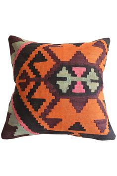 an orange and black decorative pillow sitting on top of a white wall