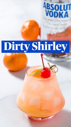 an orange cocktail with a cherry garnish on the rim and vodka bottle in the background