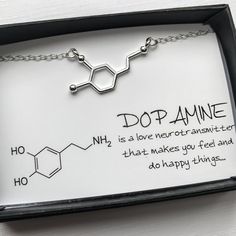 a necklace with the words dopamine written on it in black ink and silver chain