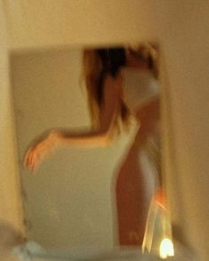 a blurry image of a woman standing in front of a mirror