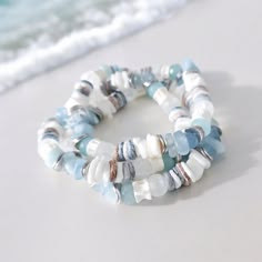 Handcrafted with meticulous care, this beach bracelet includes sea glass, shell, silver, aquamarine, and unique fish bone vertebrae beads handmade in Africa. Each element tells a story of the sea, from the intricate fish bone bead to the shimmering sea glass bead, creating a unique piece that captures the essence of ocean treasures. The delicate silver accents add a touch of sophistication, complementing the natural beauty of the shell bead to perfection. Perfect for a beach wedding or as a stat Seaglass Bracelet Diy, Beaded Beach Necklaces, Themed Bracelet Ideas, Beaded Sea Glass Jewelry For Beach, Beach Beaded Sea Glass Jewelry, White Natural Stones Bracelets For Beach, White Natural Stones Bracelets For The Beach, Light Blue Round Bead Bracelets For Beach, Light Blue Round Beaded Bracelets For Beach