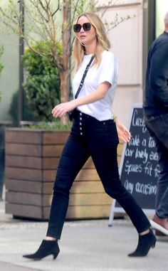 a woman walking down the street in high heels