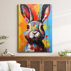 a colorful painting of a rabbit on a wall above a white couch in a living room