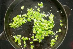 green onions are being cooked in a skillet on the stove top, with oil