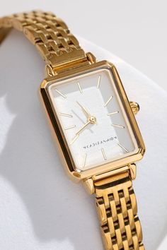 Introducing the Mila 18K Minimalist Watch, a luxurious timepiece crafted for the modern Woman. Featuring a lustrous 18K Gold detail, It's sleek design perfectly combines functionality and style. The band is expertly crafted from premium quality stainless steel to ensure durability. Elevate your everyday look with the timeless elegance of Mila. Dial Size: 26*20mm Band Width: 14mm Band Length: 23cm Movement: Japanese Quartz Each Watch will be delivered in our luxe black and gold watch box Please n Elegant Woman Watch, Classic Gold Watch Women, Elegant Gold Watch, Simple Gold Watch, Timeless Watches Women, Women’s Gold Watch, Classy Gold Jewelry, Designer Watches Women, Women Gold Watch