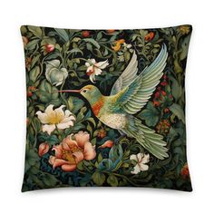 a decorative pillow with a hummingbird and flowers on the front, surrounded by foliage