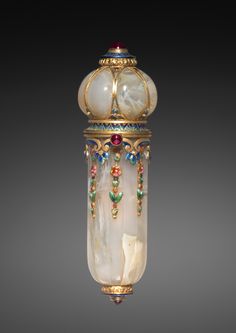 an ornately decorated glass vase with gold trimmings and colorful beads on it