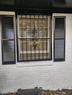 a black suitcase sitting in front of a window with bars on the windowsills