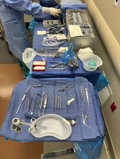 several surgical instruments are laid out on a table with blue cloths and other medical equipment