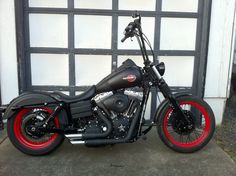 a black and red motorcycle parked in front of a garage