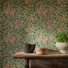 two bowls are sitting on a table in front of a wallpapered background with flowers