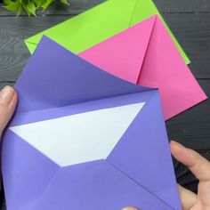 someone is holding an origami envelope in their left hand and another folded one on the other