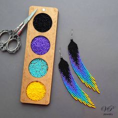 a pair of scissors sitting next to some beaded earrings on top of a table