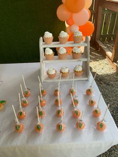 cupcakes and orange balloons are on the table