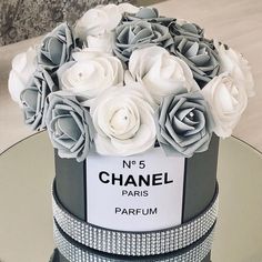 a chanel cake with white roses on top