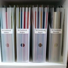 a white book shelf filled with files and binders