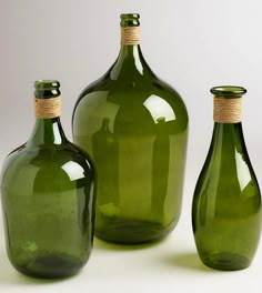 three green glass bottles sitting next to each other