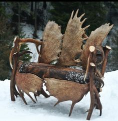 a bench made out of deer antlers in the snow