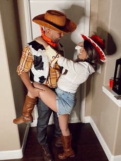 a man and woman dressed up as toy story characters, one holding the other's leg