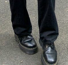 a person wearing black shoes standing on the street