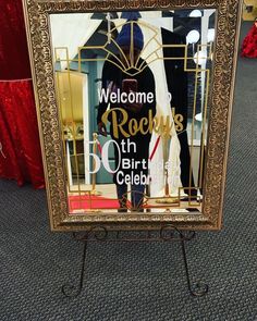 a welcome sign is displayed in front of a mirror with the words rock'n'roll's 50th celebration written on it