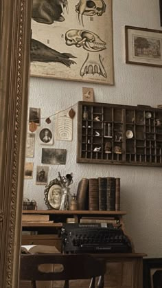 an old typewriter is sitting on a desk in front of a mirror with pictures above it