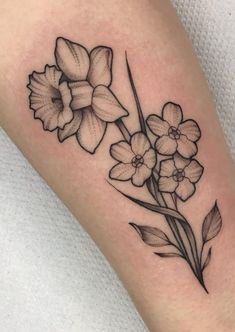 a black and white flower tattoo on the arm