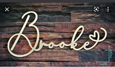 a wooden sign that reads brooke on it's side against a wood wall with the word broke written in cursive font