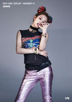 a young woman posing with her hand on her face while wearing metallic pants and a black shirt