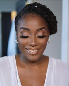 a woman smiling with her eyes closed and makeup done by an expert in the beauty industry