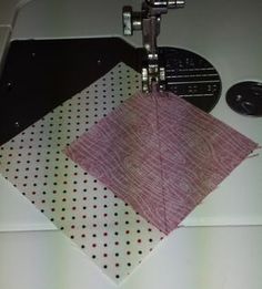 a close up of a sewing machine on a table with some fabric next to it