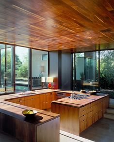 an open kitchen with wooden cabinets and counter tops in front of large sliding glass doors