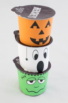 three cups with faces painted on them are stacked in the shape of witches and pumpkins