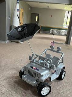 a toy jeep with an umbrella in the middle of a room filled with furniture and items