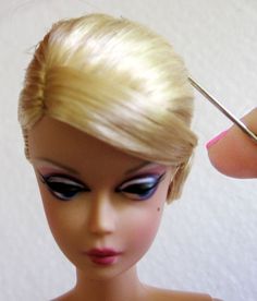 a close up of a doll with scissors in it's hair