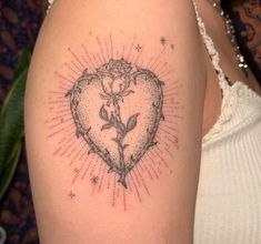 a woman's arm with a tattoo on it that has a rose in the shape of a heart