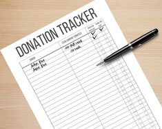 a donation tracker on top of a wooden table next to a pen and paper with the words donation tracker