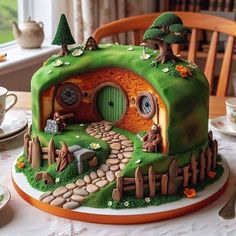 a cake that looks like a hobbot house with trees and rocks on it