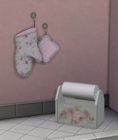 a baby's room with pink walls and floral decorations on the wall, two bibs hanging from hooks