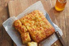 some food is laying on a cutting board next to a glass of beer and a knife