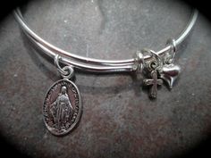 PLEASE PAY ATTENTION TO PRODUCTION AND SHIPPING TIMES AS THEY MAY BE LONGER THAN OTHER SELLERS....THANK YOU! Perfect First Holy Communion gift or special gift for a little girl! Adjustable wire bangle with small (approx. 1/2 inch) Miraculous Medal charm (double sided) and tiny cross and puffed heart charms. Comes gift boxed with ribbon. Available in stainless steel or silver plated; cross may vary from photo. For the adult size version of this bracelet ( I can add a heart charm if you wish) http Bracelet With Cross, Dachshund Jewelry, Arm Bracelets Upper, Wedding Jewelery, Wire Bangle Bracelets, Gothic Bracelet, Signature Bracelet, Hammered Bangles, Handwriting Jewelry