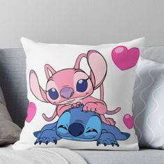 a pink and blue cartoon character sitting on top of a baby stitcher throw pillow