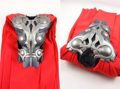 the mask is made out of metal and sits on top of a red piece of cloth