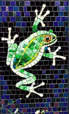 a green frog sitting on top of a tiled wall