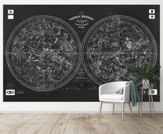 a black and white wall mural with an old world map on it, next to a chair